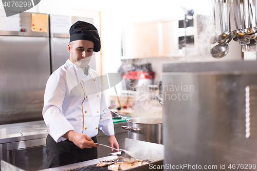 Image of chef preparing food, frying on grill