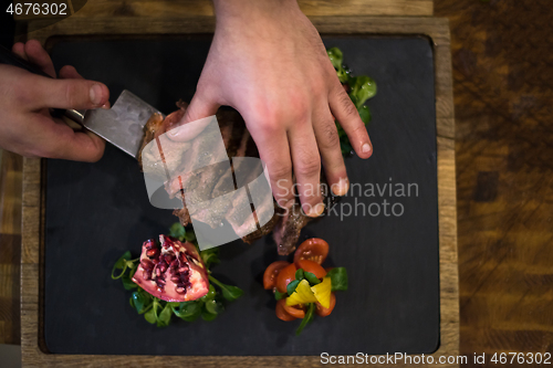 Image of top view of Chef hands serving beef steak