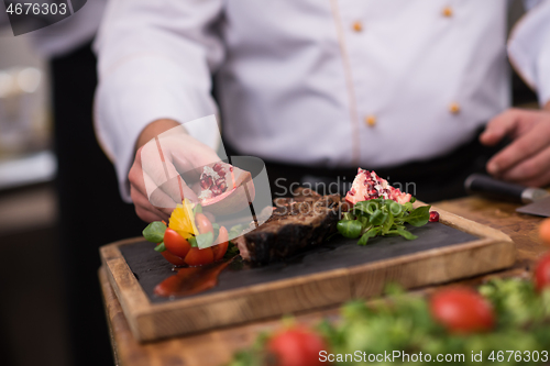 Image of closeup of Chef hands serving beef steak