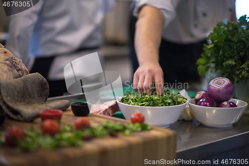 Image of chef hand serving vegetable salad