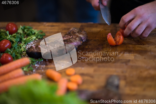 Image of closeup of Chef hands preparing beef steak