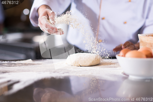 Image of chef hands preparing dough for pizza