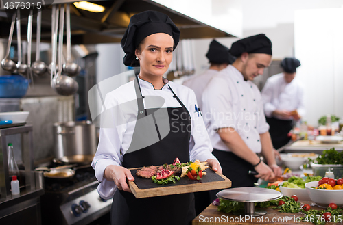 Image of female Chef holding beef steak plate