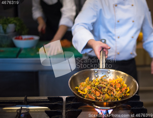 Image of chef flipping vegetables in wok
