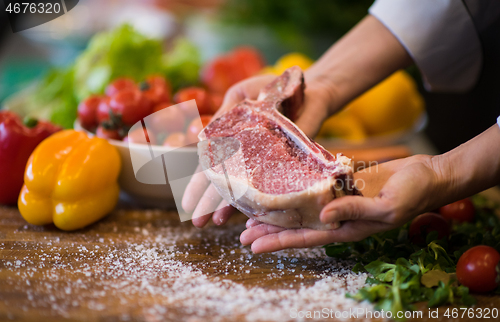 Image of Chef holding juicy slice of raw steak