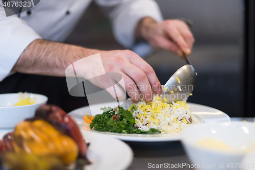 Image of Chef hands serving vegetable risotto