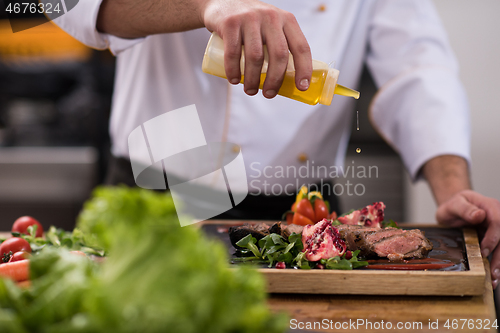 Image of Chef finishing steak meat plate