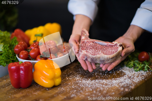 Image of Chef holding juicy slice of raw steak