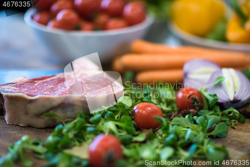 Image of Juicy slice of raw steak on wooden table