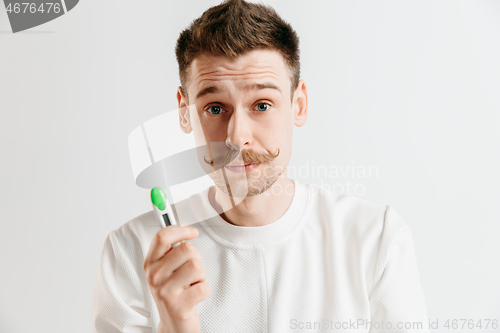 Image of Upset man looking in pregnancy test. Frustrated model