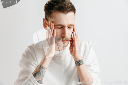 Image of Man having headache. Isolated over gray background.