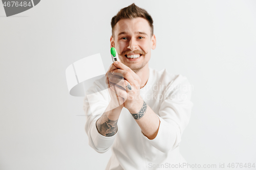 Image of Happy man looking at pregnancy test at studio