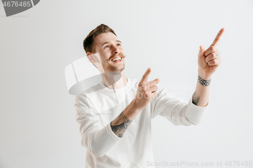 Image of The happy businessman standing and smiling against gray background.