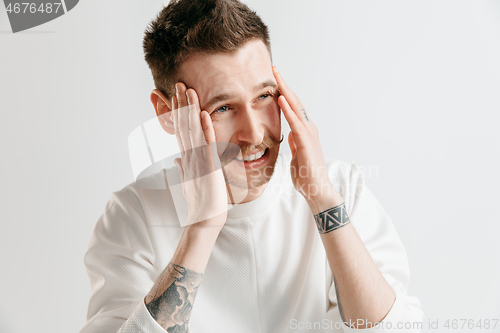 Image of Man having headache. Isolated over gray background.