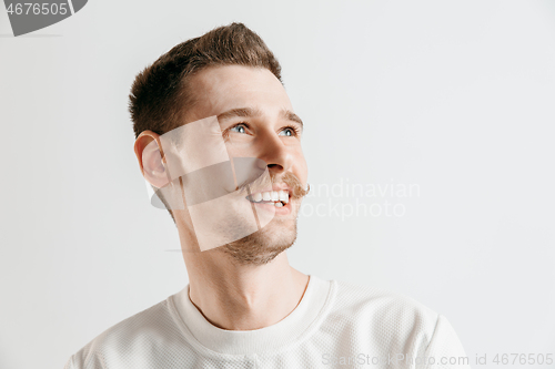 Image of The happy businessman standing and smiling against gray background.