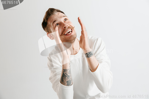 Image of The happy businessman standing and smiling against gray background.