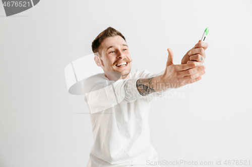 Image of Happy man looking at pregnancy test at studio