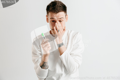 Image of Upset man looking in pregnancy test. Frustrated model