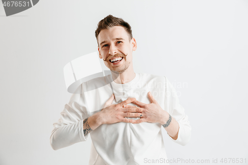 Image of The happy businessman standing and smiling against gray background.