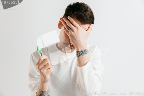 Image of Upset man looking in pregnancy test. Frustrated model