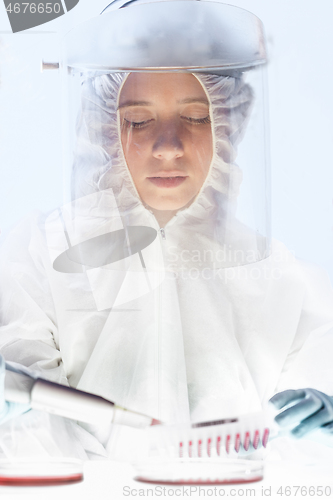 Image of Female scientist working in the corona virus vaccine development laboratory research with a highest degree of protection gear.