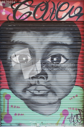 Image of BARCELONA, SPAIN - JUNE 2, 2013: Portrait of a cute black kid painted on the door