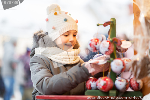 Image of little girl choosing christmas balls at market