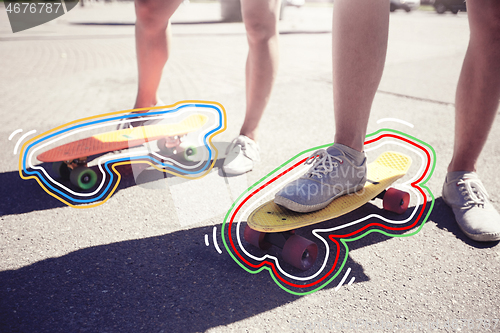 Image of teenage couple riding skateboards on city street