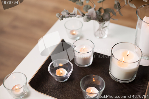 Image of candles and branches of eucalyptus on table