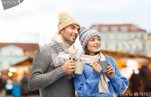 Image of happy couple drinking coffee at christmas market