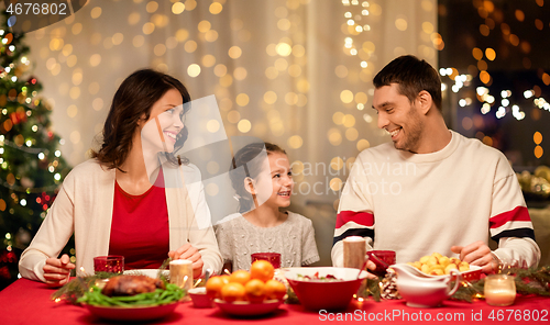 Image of happy family having christmas dinner at home