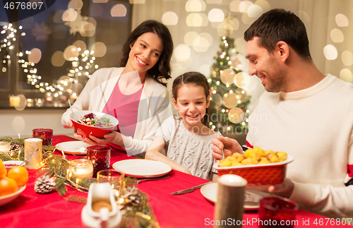 Image of happy family having christmas dinner at home