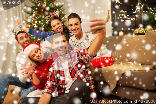 Image of friends celebrating christmas and taking selfie