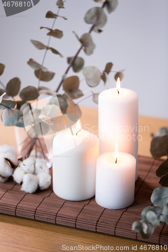 Image of candles and branches of eucalyptus on table