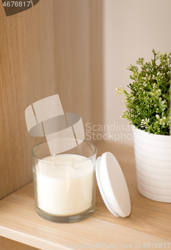 Image of fragrance candle in glass holder on shelving