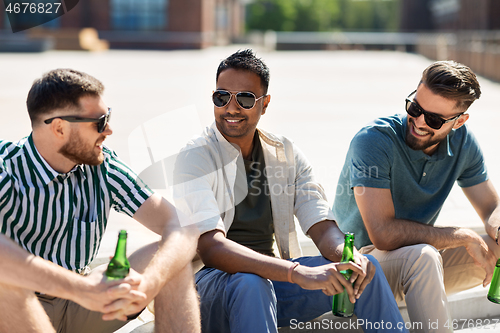 Image of happy male friends drinking beer on street