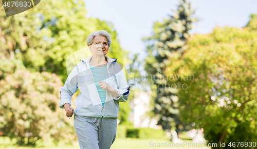 Image of senior woman running along summer park