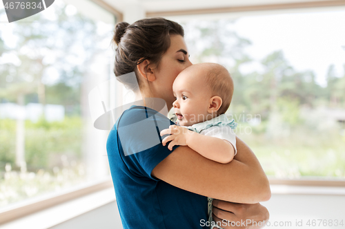 Image of mother holding baby daughter at home