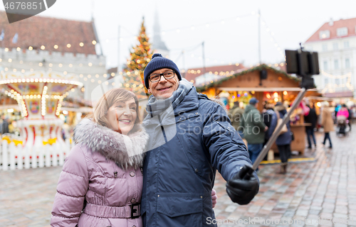 Image of senior couple taking selfie at christmas market