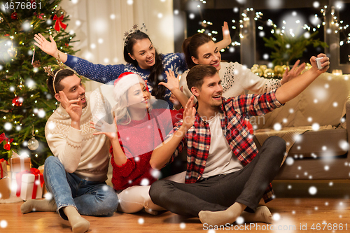 Image of friends celebrating christmas and taking selfie