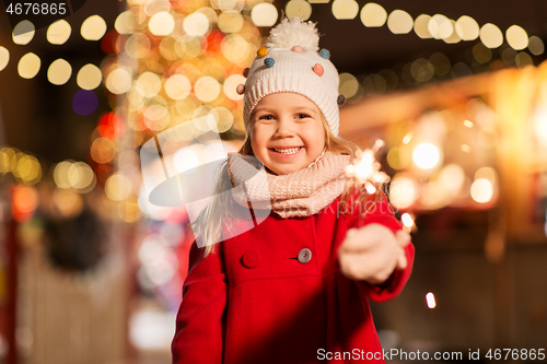 Image of happy girl with sparkler at christmas market