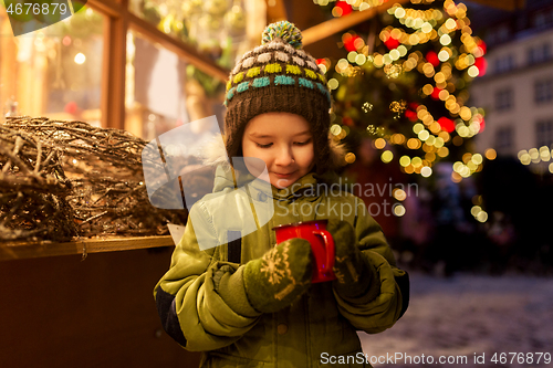 Image of happy boy with cup of tea at christmas market