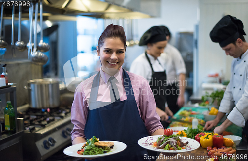 Image of young waitress showing dishes of tasty meals