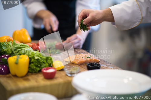 Image of Chef hands preparing marinated Salmon fish