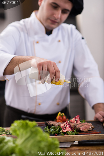 Image of Chef finishing steak meat plate