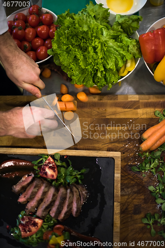 Image of top view of Chef hands serving beef steak