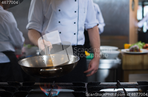 Image of chef flipping vegetables in wok