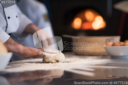 Image of chef hands preparing dough for pizza