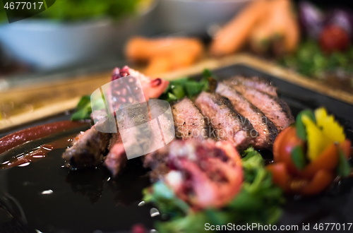 Image of Juicy slices of grilled steak on wooden board