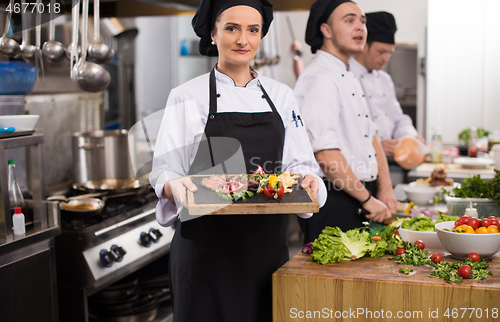 Image of female Chef holding beef steak plate